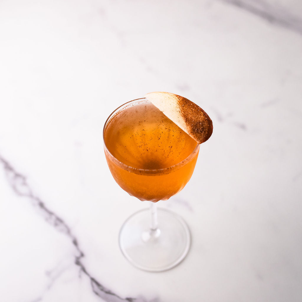 Bass & Flinders distillery golden orchard apple brandy cocktail in glass with cinnamon dusted apple slice garnish