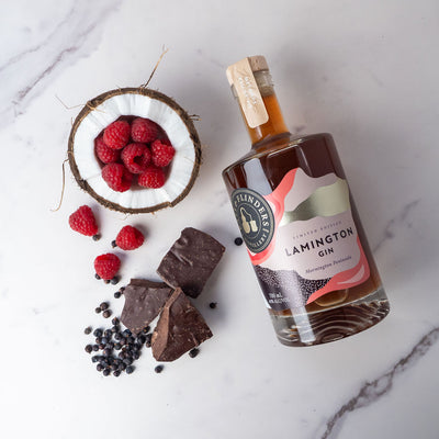 Bottle of Bass & Flinders Distillery Lamington Gin with chocolate, berries, and coconut on a marble surface