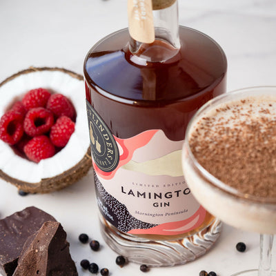 Bottle of bass & flinders distillery Lamington Gin with creamy coconut cocktail and half coconut filled with raspberries